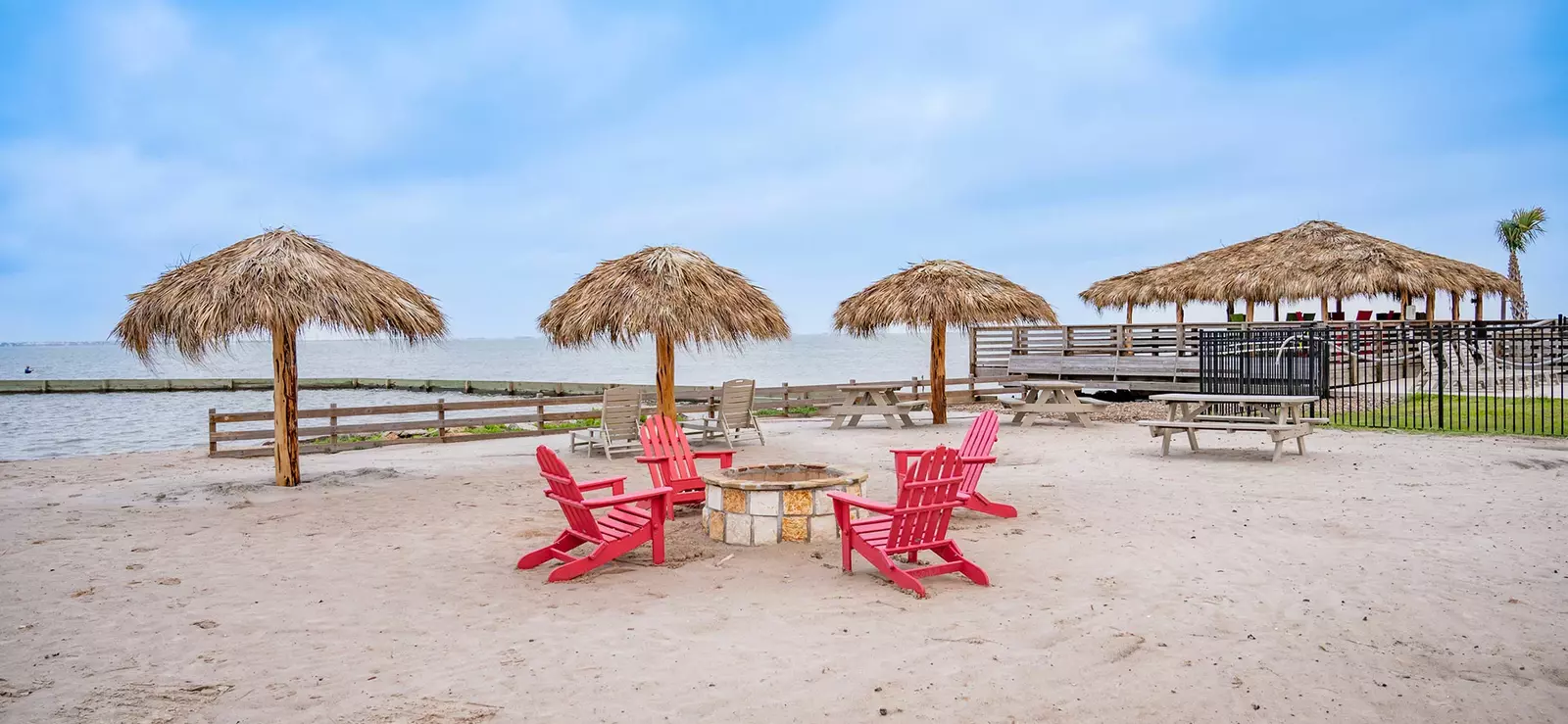 Fire pit and sitting area on beach by ocean